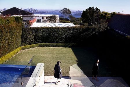 The Sydney Opera House and Harbour Bridge can be seen behind real estate agent LuLu Sun (R) as she escorts Bao Fang, a potential buyer from Shanghai, during an inspection of a property for sale in the Sydney suburb of Vaucluse, Australia, July 11, 2015. REUTERS/David Gray